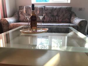 a glass table with a bottle of wine and two wine glasses at Oasis in Aspindza
