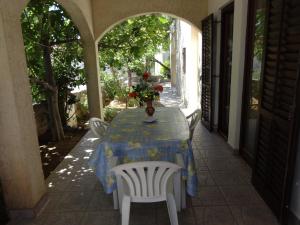 a table with a vase of flowers on top of it at Apartments Palma in Vir