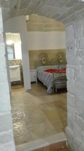 een slaapkamer met een bed en een stenen muur bij Dimora Termite Pietà in Bitonto