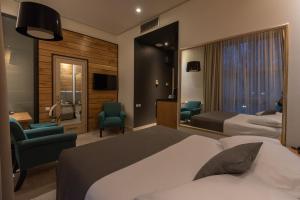 レスコヴァツにあるHotel ABCのベッド2台、椅子、テレビが備わるホテルルームです。