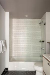 a bathroom with a white tub and a toilet at ROOST East Market in Philadelphia