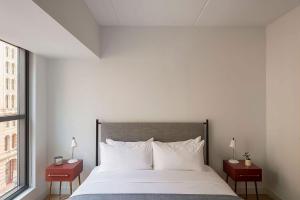 a bedroom with a bed and a window at ROOST East Market in Philadelphia