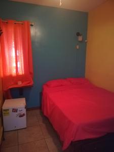 a bedroom with a red bed and a red window at Cliff's Hostel in La Gruta