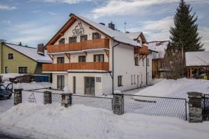 ein Haus im Schnee mit einem Zaun in der Unterkunft Villa 1 in Wisła