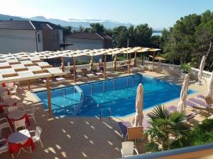 a large swimming pool with chairs and umbrellas at Hotel Gjoci in Shëngjin