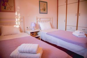 a bedroom with two beds with towels on them at Traditional House in the Centre of Vasiliki in Vasiliki