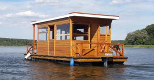 a tiny house on a dock in the water at Hausboot / Floss in Canow