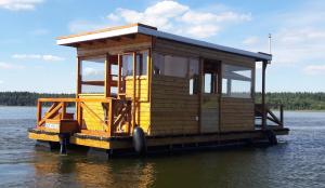 ein kleines Haus auf einer Anlegestelle im Wasser in der Unterkunft Hausboot / Floss in Canow