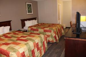 a hotel room with two beds and a flat screen tv at Regency Inn in Rolla