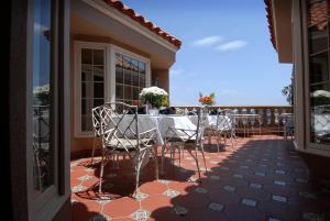 um pátio com uma mesa e cadeiras numa varanda em Doryman's Oceanfront Inn em Newport Beach