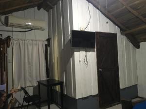 a room with a tv on a wall with a table and a table sidx at Hotel Samsara in Uvita
