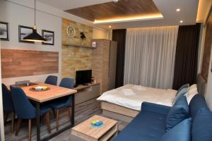 a hotel room with a bed and a dining room at Apartman Sladjana Premier 12 Milmari in Kopaonik
