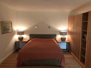 a bedroom with a bed and two lamps on two tables at Hof Kaltenbrunn in Aying