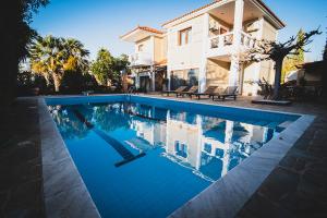 a swimming pool in front of a house at Villa Soula in Anavissos