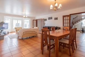 a dining room and living room with a table and chairs at Casa dos Amigos in Ribeira Grande