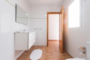 Baño blanco con lavabo y espejo en Apartamentosánchez en Vecindario
