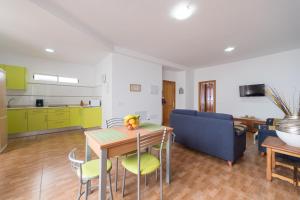eine Küche und ein Wohnzimmer mit einem Tisch und Stühlen in der Unterkunft Apartamentosánchez in Vecindario