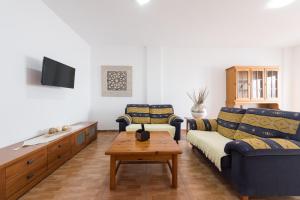 ein Wohnzimmer mit einem Sofa und einem Couchtisch in der Unterkunft Apartamentosánchez in Vecindario