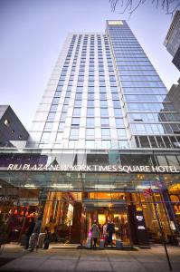 紐約的住宿－Riu Plaza New York Times Square，一座高大的建筑,前面有人站在