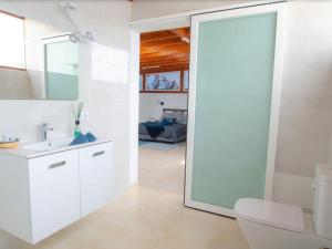 a white bathroom with a sink and a mirror at Las Arecas Loft in Playa Blanca