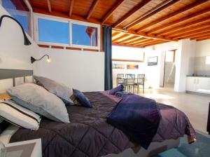 プラヤ・ブランカにあるLas Arecas Loftのベッドルーム1室(大型ベッド1台、枕付)、キッチンが備わります。