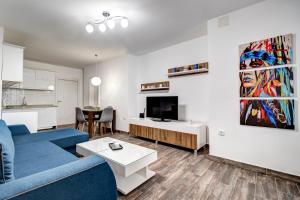 a living room with a blue couch and a tv at HOUSE OF SURPRISE in Užice