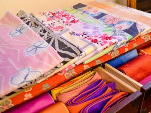 un cajón lleno de diferentes tejidos y sombrillas de colores en Sanso Matsuya, en Yufu