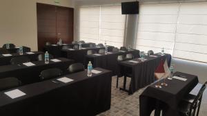 a room with tables and chairs with water bottles on them at Hoteles Riviera Colonial in Arequipa