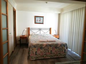 a bedroom with a bed and two tables and two lamps at The Sedgebrook On Leichhardt in Brisbane +50 photos