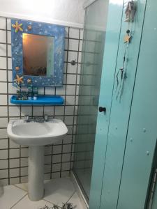 a bathroom with a sink and a mirror at Chalé Boiçucanga / Maresias in Boicucanga