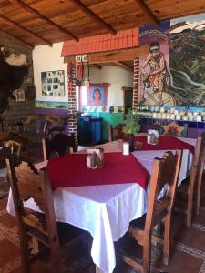 un comedor con 2 mesas y un mural en Rancho Cabañas San Isidro en Cerocahuí
