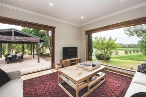 a living room with a couch and a table and a television at Eurunderee House in Eurunderee