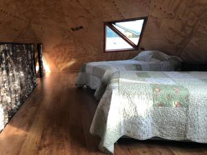 - une chambre avec 2 lits dans une cabane en bois dans l'établissement Domo Trasmahue, à Villarrica