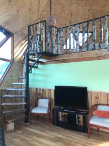 a living room with a staircase and a flat screen tv at Domo Trasmahue in Villarrica