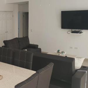 a living room with a couch and a flat screen tv at Corona Del Sol 1104, Puerto Peñasco, Las Conchas in Puerto Peñasco
