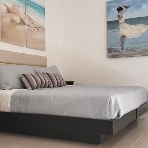 a bedroom with a bed with two paintings on the wall at Corona Del Sol 1104, Puerto Peñasco, Las Conchas in Puerto Peñasco +33 photos