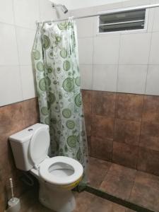y baño con aseo y cortina de ducha. en Central Paz Hostel en Villa Carlos Paz