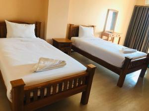 1 dormitorio con 2 camas y espejo en BP Grand Hotel, en Chiang Mai