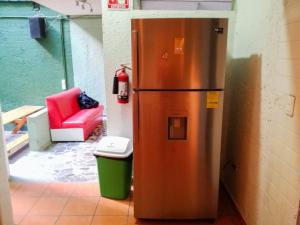 a stainless steel refrigerator in a room with a red chair at Guest Green in Ciudad Nezahualcóyotl