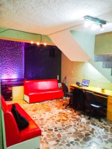 a living room with a red couch and a desk at Guest Green in Ciudad Nezahualcóyotl