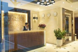 a woman sitting at a counter in a store at The Confetti hotel in Ha Long