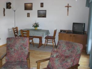 ein Wohnzimmer mit einem Tisch und Stühlen sowie einem TV in der Unterkunft Ferienwohnungen Winter in Lohberg