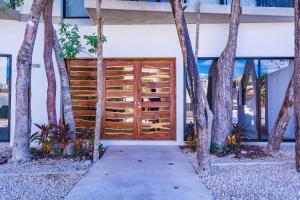 a wooden door in front of a building with trees at Mi Tulum in Tulum