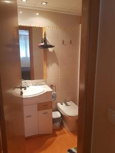 La salle de bains est pourvue d'un lavabo, de toilettes et d'un miroir. dans l'établissement Chillout Grau de Gandia- attico para 6 personas invitamos familias y jovenes, dos banos, à Gandía