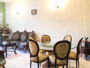 Redzuan Homestay (Muslim Friendly) في موار: غرفة طعام مع طاولة وكراسي زجاجية