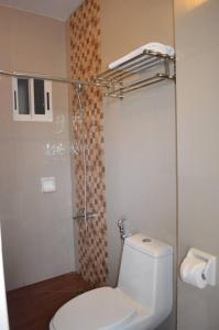 a bathroom with a white toilet and a shower at Taj Guesthouse Boracay in Boracay