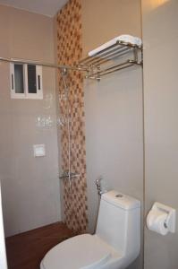 e bagno con servizi igienici bianchi e doccia. di Taj Guesthouse Boracay a Boracay