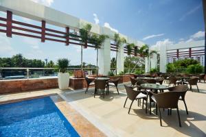 a patio area with tables, chairs and umbrellas at Novotel Chennai Sipcot in Chennai