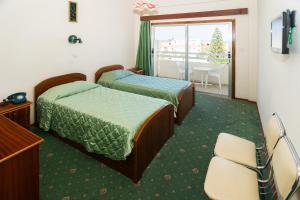 Ένα ή περισσότερα κρεβάτια σε δωμάτιο στο Ξενοδοχείο Μάριον