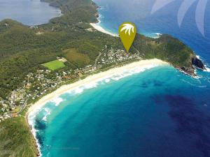 a yellow object is flying over a beach at Twin Peaks 2 in Blueys Beach